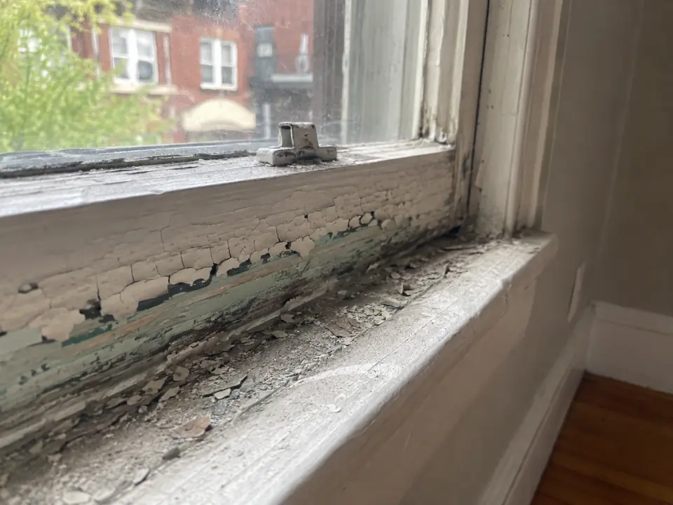 Peeling paint on an old wooden window sash